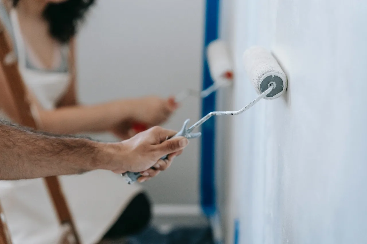 couple painting white brush wall quantum vice