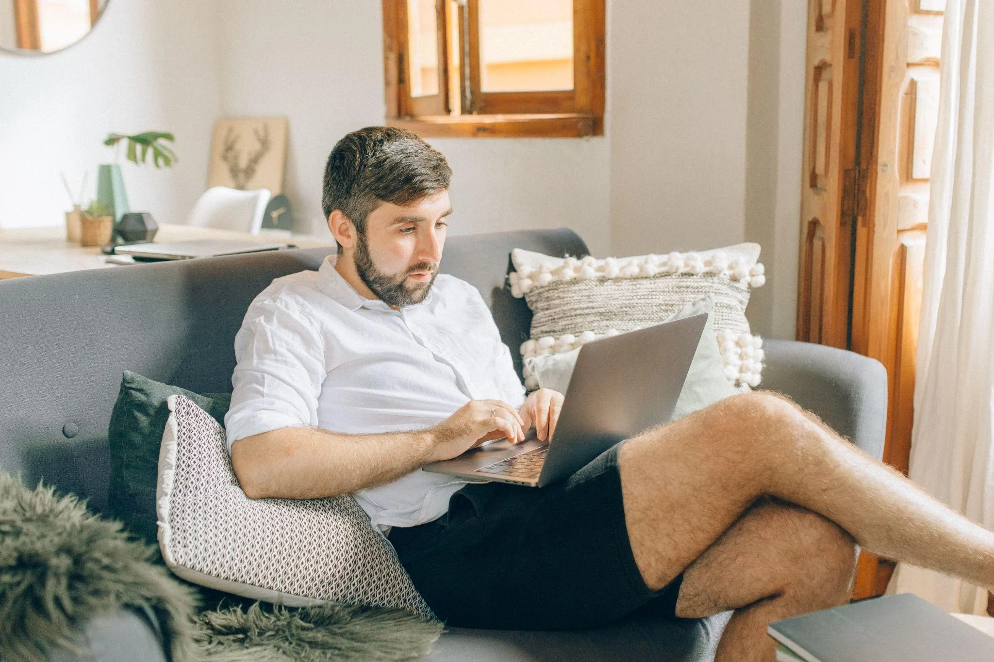 man using laptop sitting down on couch quantum vice
